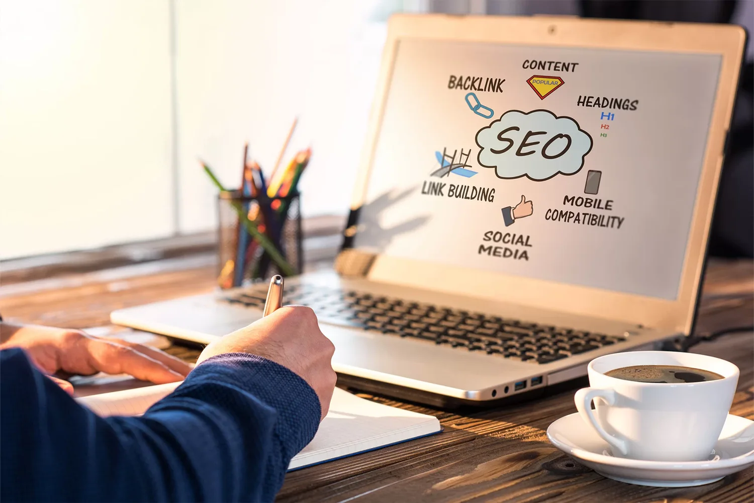 SEO-Schaubild auf einem Laptopbildschirm: Inhalte, Überschriften, Backlinks, mobile Optimierung und Social Media